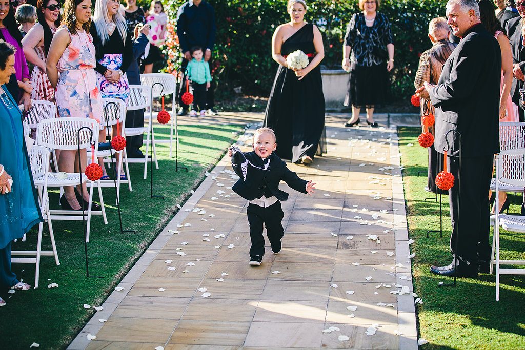 The cute little ring bearer sprinting down the wedding aisle with the rings!