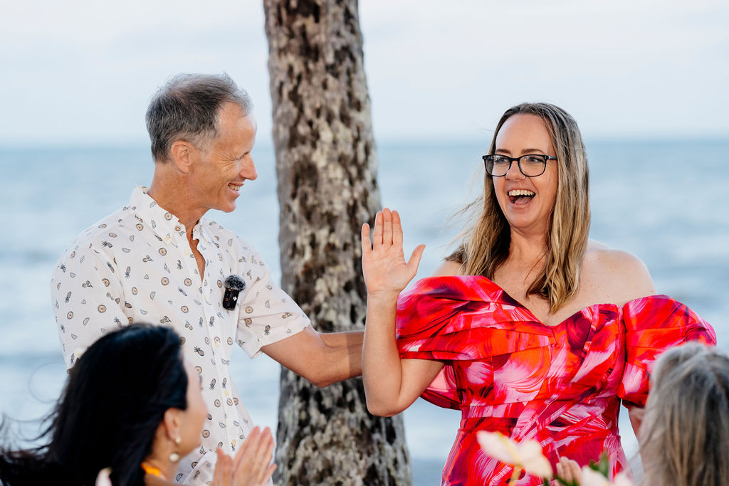 The With Love Elopements difference, Celebrants Jamie and Cara with Cara raising her hand as if to indicate 'me' or 'yes'