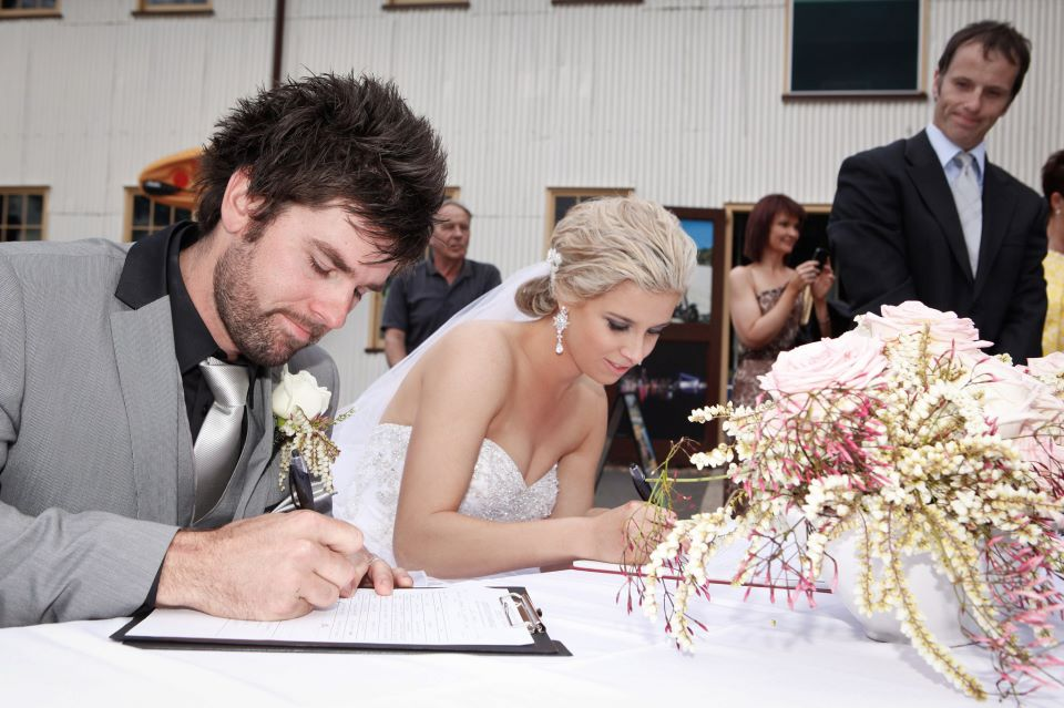 Riverlife Wedding winners Katrina and Nat signing the marriage register with Jamie Eastgate, Brisbane Celebrant