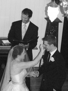 The bride lovingly wiping the grooms happy tears